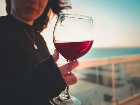 Frau hält ein Glas Rotwein in der Hand