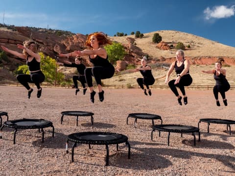 Frauen springen in der Wüste Trampolin