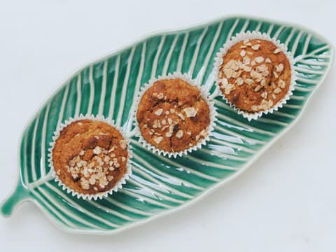 Drei Haferflockenmuffins auf einem blattförmigen Teller
