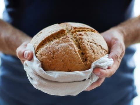Person hält Brotlaib in den Händen