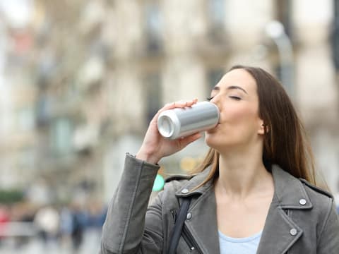 Frau trinkt aus Dose