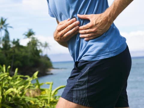 Mann hält sich beim Joggen die linke Seite