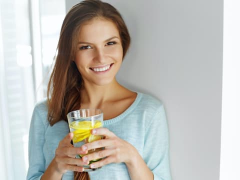 Frau trinkt Zitronenwasser