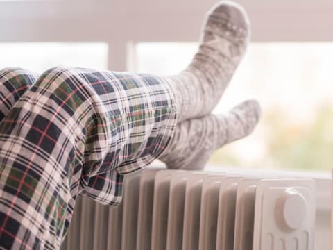 Füße in Wollsocken auf einer Heizung