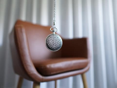 Taschenuhr vor einem Stuhl