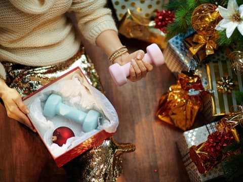 Frau packt Hanteln als Weihnachtsgeschenk aus
