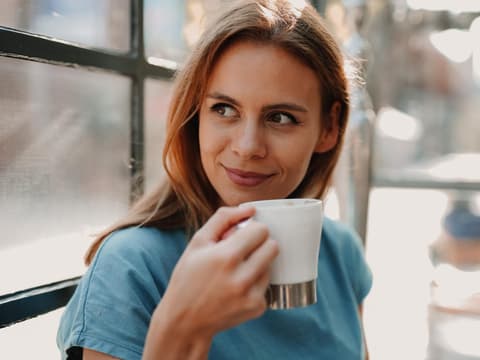 Frau trinkt aus einer Kaffeetasse