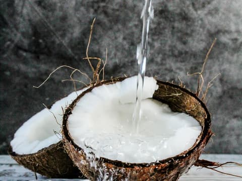Reife Kokosnuss mit Fruchtfleisch und Wasser