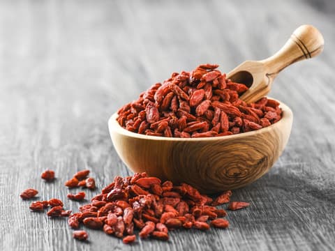Goji-Beeren in Holzschale auf rustikalem Tisch