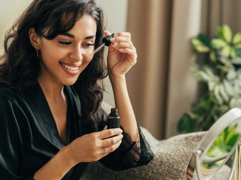 Frau trägt Retinol-Serum auf