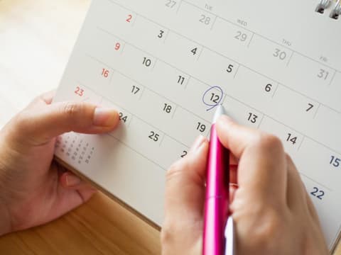Frau berechnet ihren Eisprung am Kalender