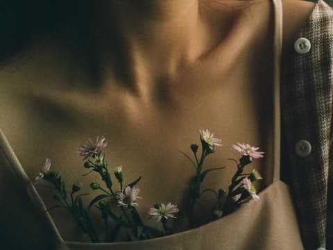 Blumen sprießen aus Dekolettee bei Frau