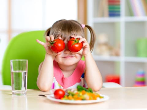 Kind mit Tomaten