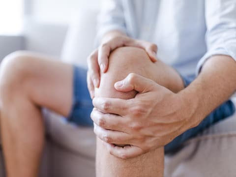 Mann hat Schmerzen im Knie