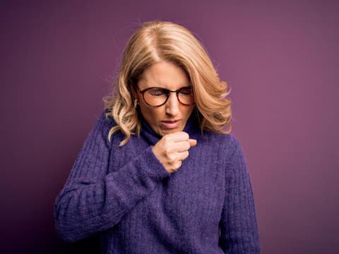 Frau hustet in Faust