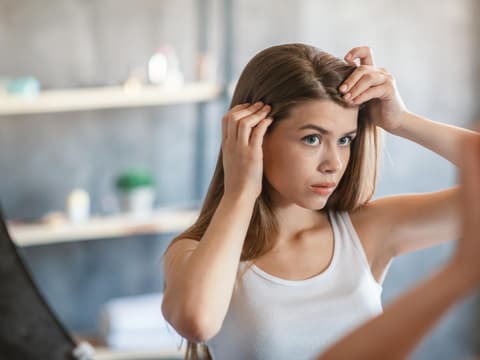 Frau begutachtet ihre Haare