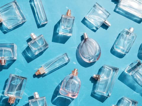 klare, reine Parfums in Flakons auf blauem Untergrund