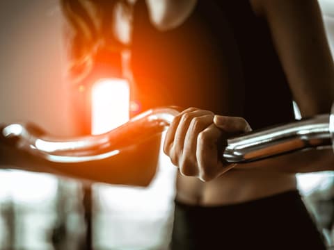 Frau trainiert Arme mit EZ-Hantel