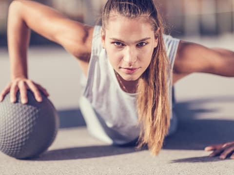 Frau macht Liegestütz mit Ball