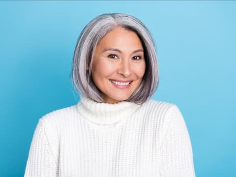 Frau mit grauen Haaren blauer Hintergrund