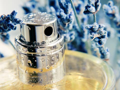Nahaufnahme Parfumflakon mit blauem Lavendel