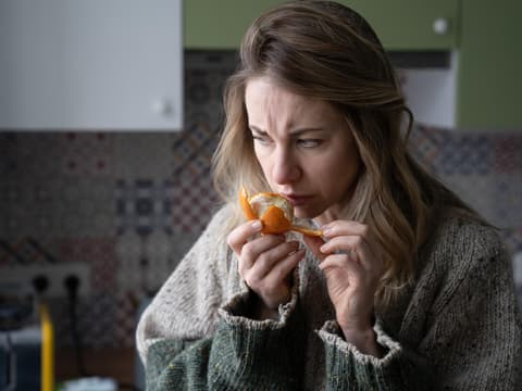 Frau riecht an Orange 