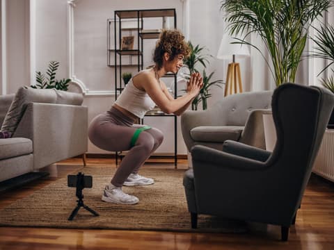 Frau macht Squats in der Wohnung