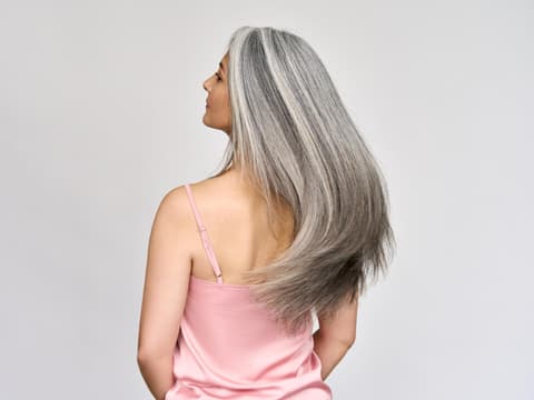 Rüclansicht einer reifen Frau mit langen grauen Haaren