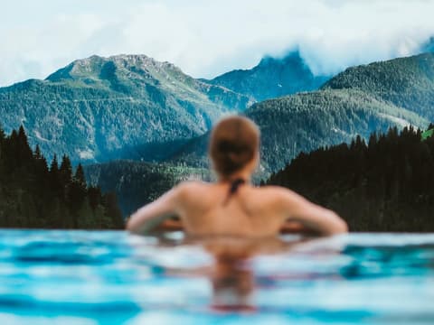 Frau im Pool mit Blick auf die Berge