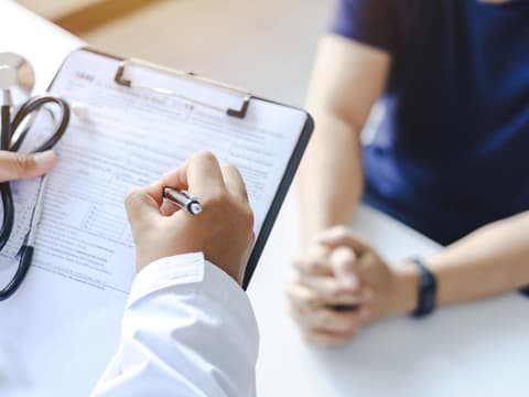 Arzt mit Clipboard untersucht Patienten