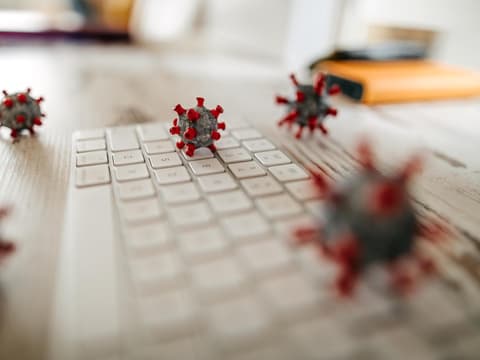 Modelle von Keimen liegen auf einer Tastatur