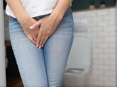 Frau hält sich die Blase
