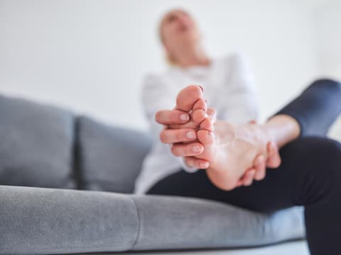 Frau hält sich schmerzenden Fuß