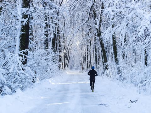 Mann joggt im Schnee