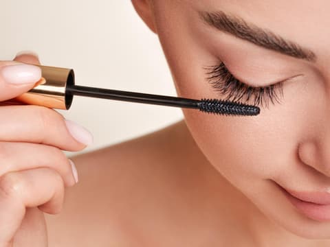 Frau tuscht Wimpern