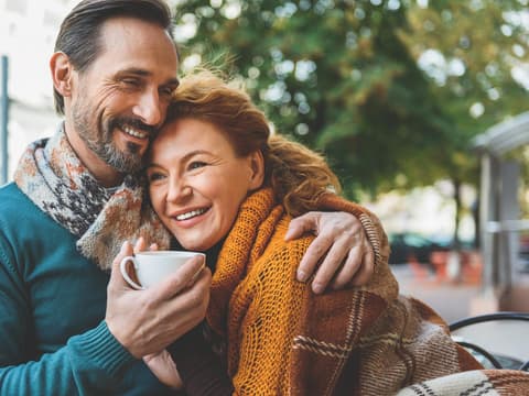 Mann und Frau halten sich im Café im Arm