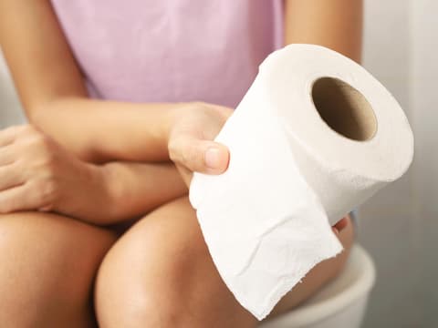 Frau auf Toilette