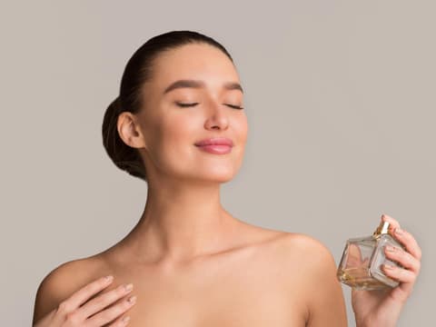 Frau trägt Parfum auf