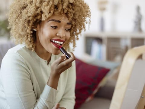 Frau trägt Lippenstift auf