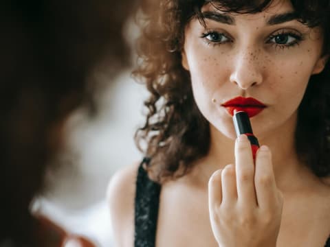Frau trägt Lippenstift auf
