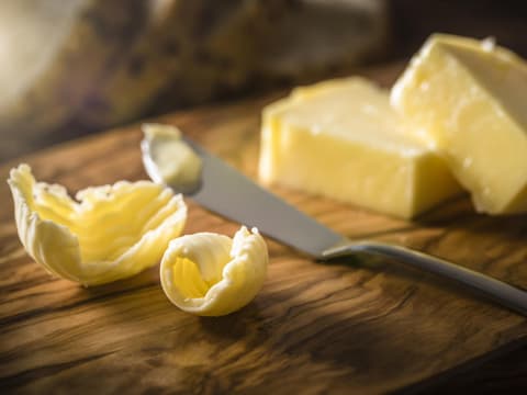 Nahaufnahme von Margarine und Buttermesser auf Holzbrett