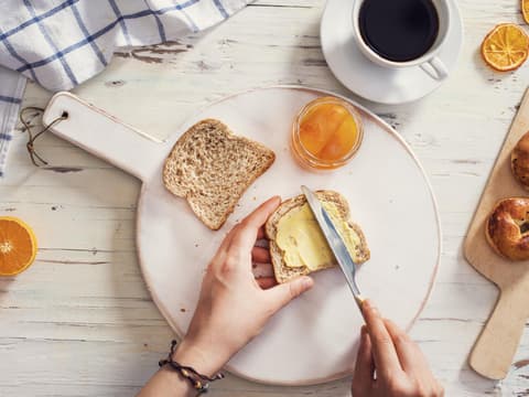 Mann schmiert Margarine auf Toast