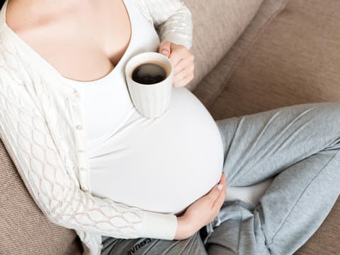 Schwangere Frau trinkt Kaffee