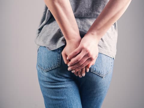 Frau hält die Hände vor den Po