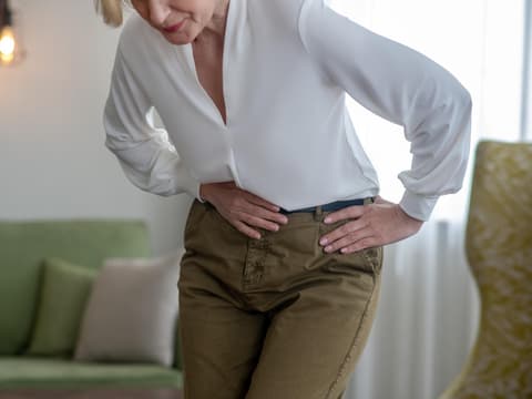 Ältere Frau hält sich den Bauch
