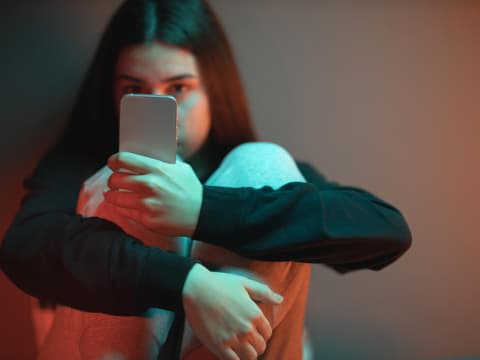 Junges Mädchen starrt süchtig auf Handy