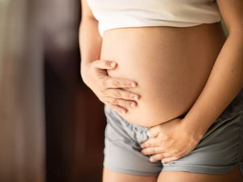 Schwangere hält sich den Bauch