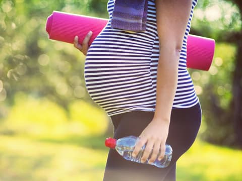 Schwangere Frau mit Sportausrüstung