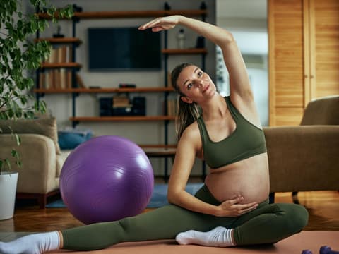 Schwangere Frau macht Sport-Übungen