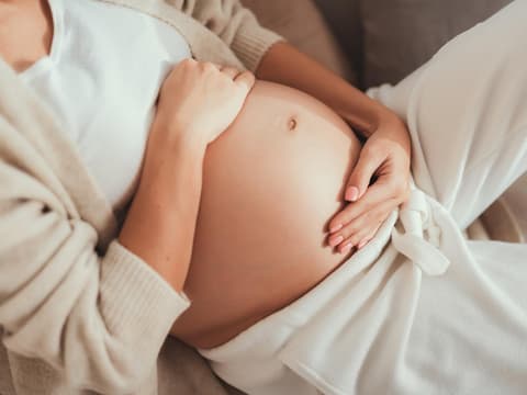 Schwangere hält Hände auf dem Bauch